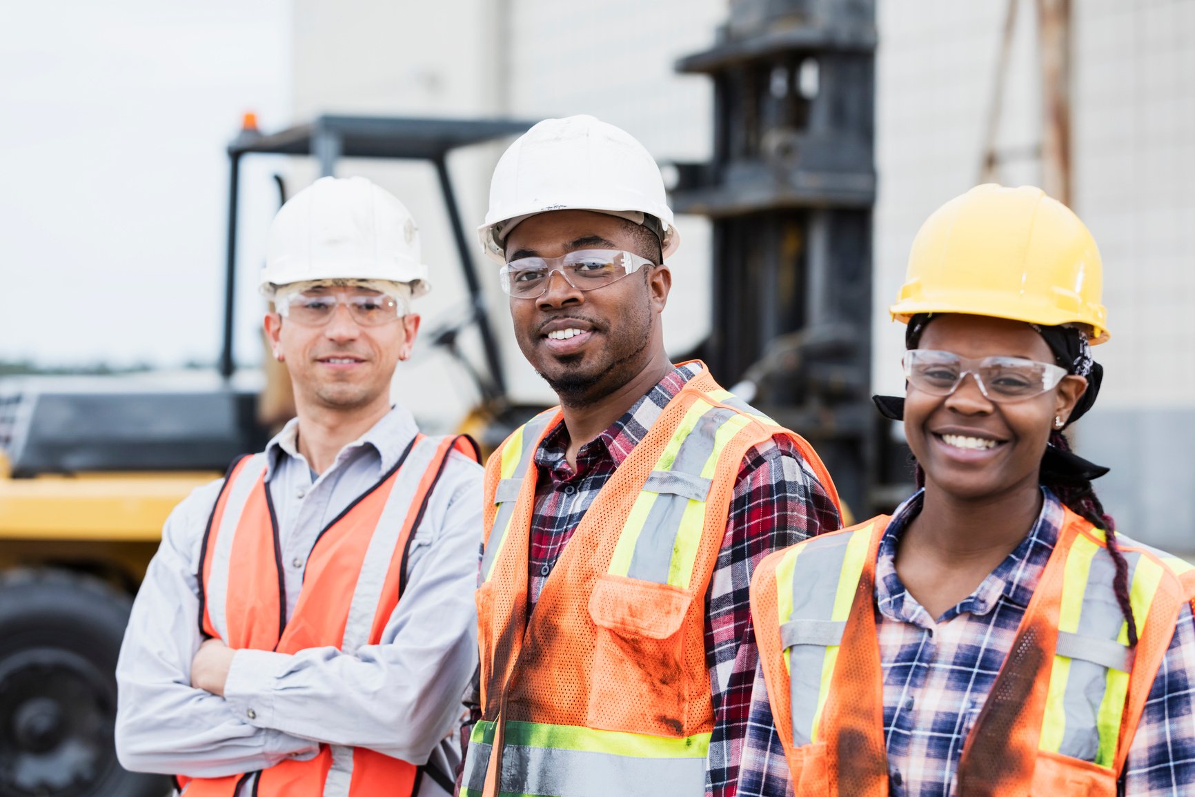 Three construction workers in hardhats and safety vests